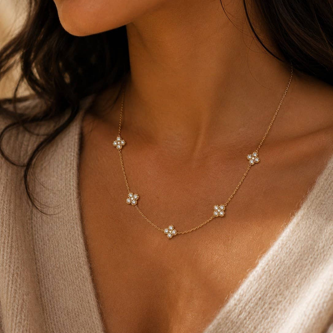 Collier fin trèfles pierres blanches délicates acier doré