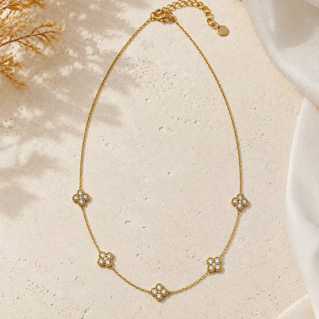 Collier fin trèfles pierres blanches délicates acier doré
